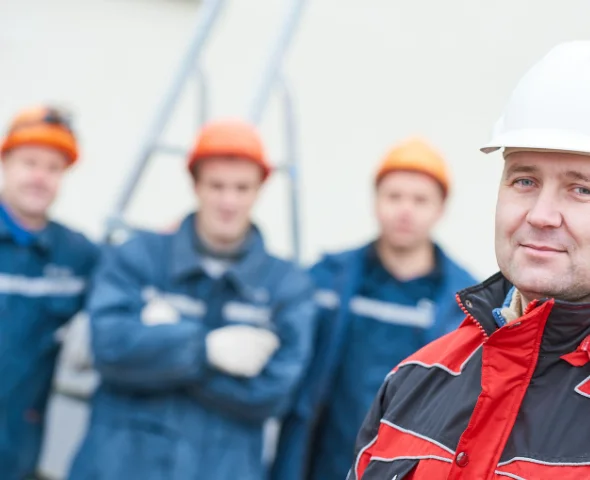 kollegen tragen gemeinsam gerüstrohre zum aufbauort