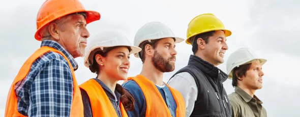 motiviertes team von gerüstbauern bei sonnigem wetter auf baustelle